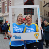 Two Sheffield Children's Hospital Charity runners pose inside o a picture frame at the Sheffield Half Marathon